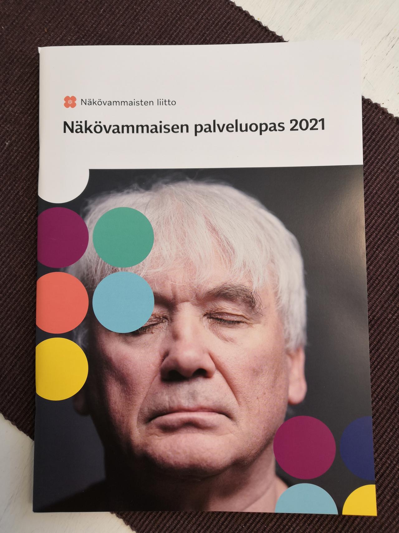 Palveluoppaan kansikuka, harmaahiuksinen mies silmät kiinni.