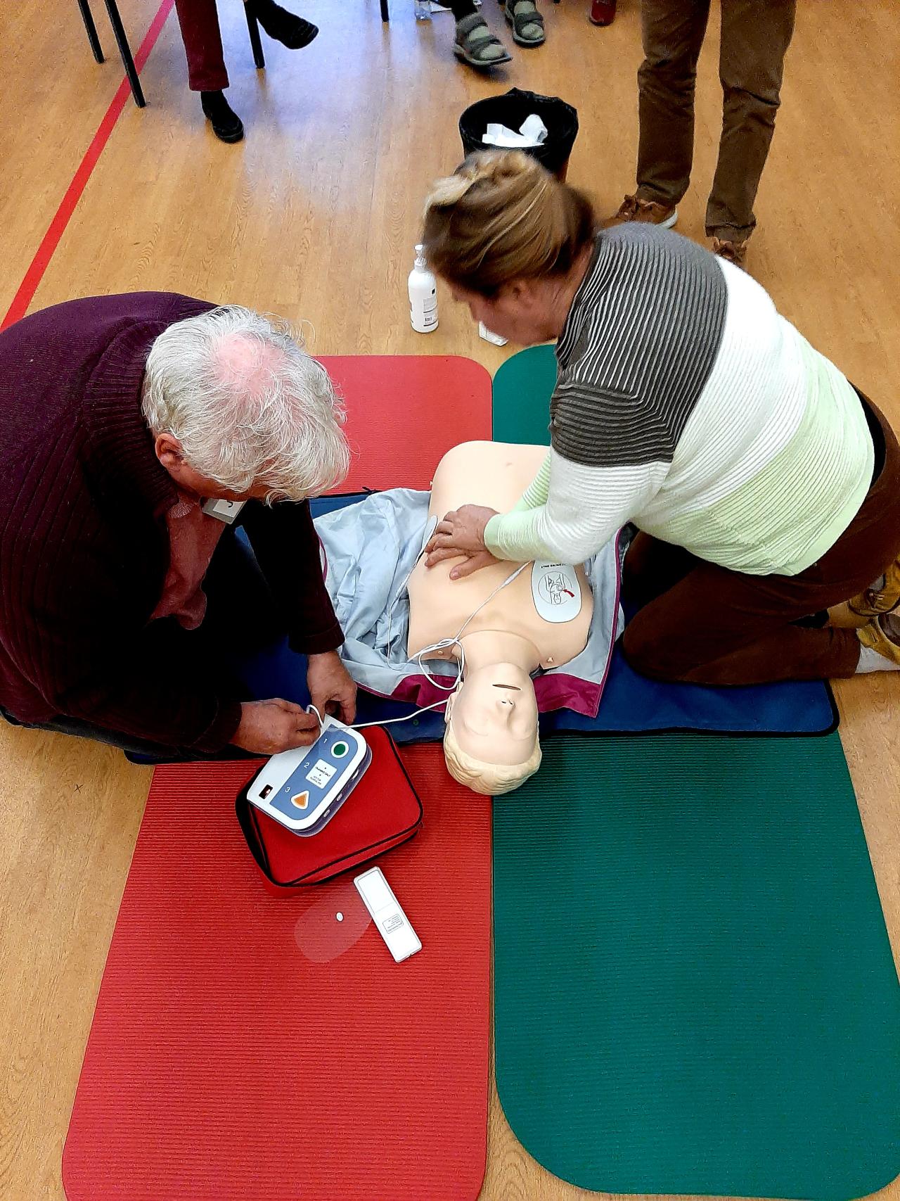 Kurssilaiset harjoittelevat painelu-puhalluselvytystä defibrillaattorin avulla.