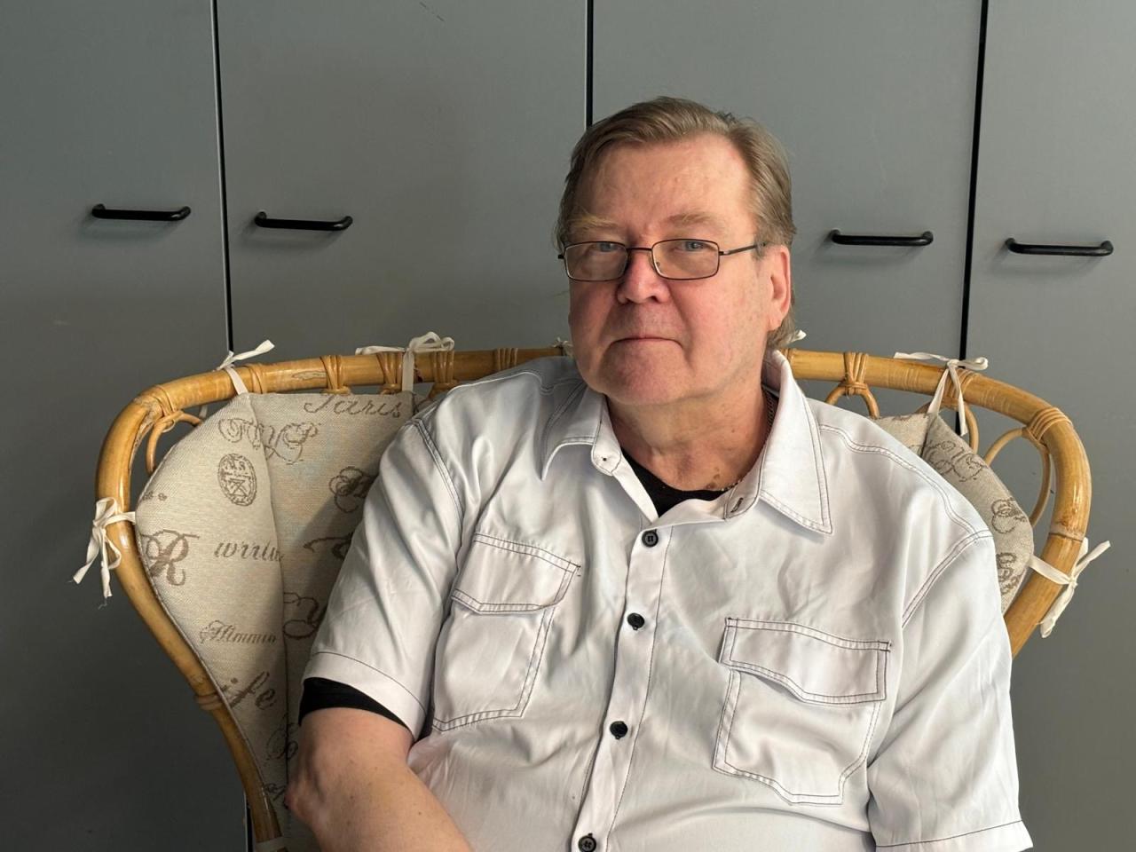 Simo Parviainen istuu Annansilmät-Aitan entisessä myymälätilassa Laura-rottinkituolissa.