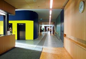 Iiriksen aula, josta johtaa pitkä käytävä suoraan eteenpäin. Vasemmalla on infotiski sekä hissit.