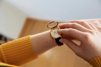 Henkilö tunnustelee ranteessaan olevaa pistekelloa